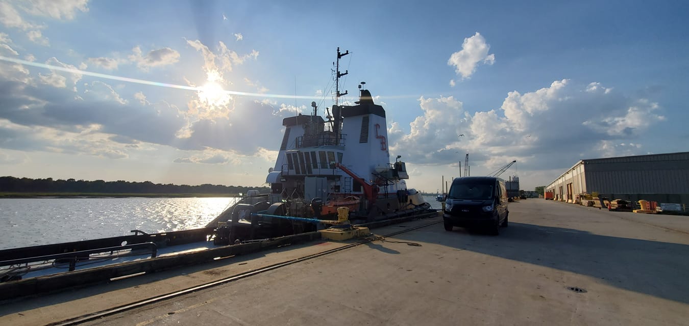 Tugboat docked beside a Performance Glass Works service van